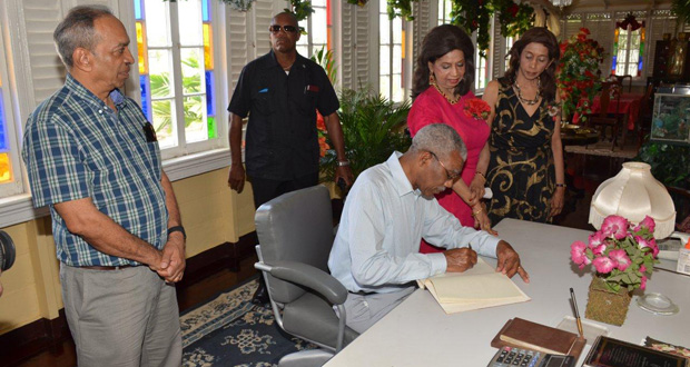 President David Granger signing the Dharm Shala Visitor’s Book after enjoying the annual Christmas luncheon with residents. Mr. Edward Boyer of the National Hardware (left) and Misses Kella and Pamela Ramsaroop (right) look on.
(Ministry of the Presidency Photo)