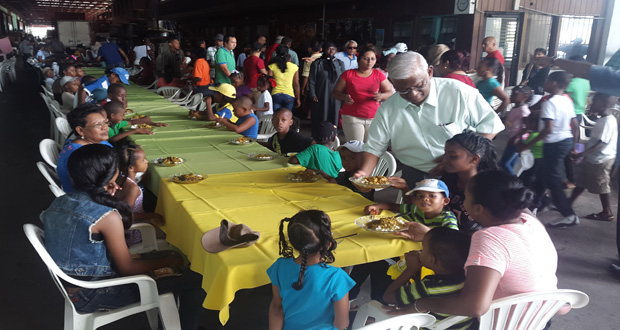 Sattaur Gafoor serving one of the many rows of tables made available for children to have a meal before receiving their gifts