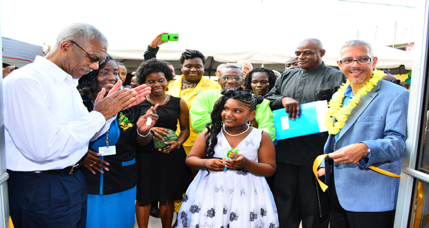 President David Granger applauds as a young girl cuts the ceremonial ribbon for the re-launching of the Linden Enterprise Network. Minister of Business Dominic Gaskin and others look on (Samuel Maughn photo)