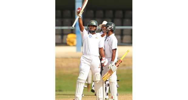Assad Fudadin raises his bat after reaching his century against Red Forc at the Queen’s Park Oval on day three. Shivnarine Chanderpaul smiles. (WICB photo-Ashley Allen)