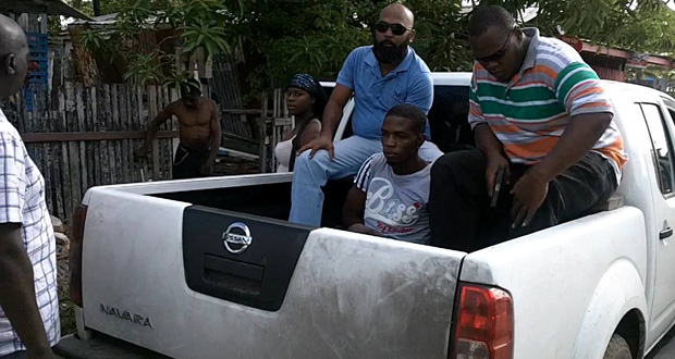Staymon George, centre, with detectives shortly after he was arrested in Tucville yesterday. It is believed that George drove the car which picked up Dominic Bernard on October 14 last. (Photo credit: NCN)