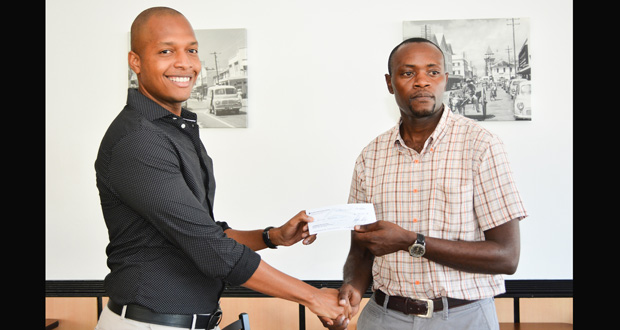 Clinton Urling (left) makes the presentation to GBSA president Rolland Tappin yesterday. (Samuel Maughn photo)