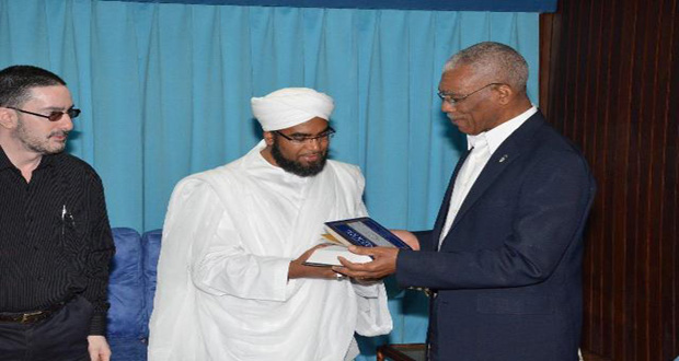 Shaykh Faid Muhammad Said handing over a copy of the Holy Quran to President Granger