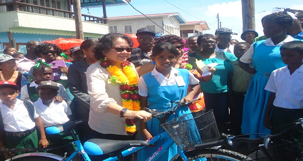 A student from Manchester Secondary School receives her bicycle from First Lady Sandra Granger