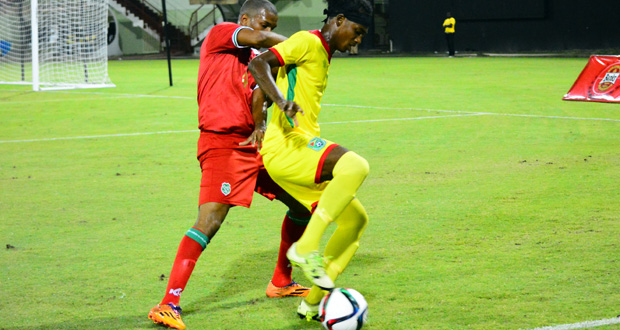 Gregory ‘Jackie Chan’ Richardson blocks a Surinamese defender during his side’s 2-0 win at the Guyana National Stadium, Providence on Sunday. (Samuel Maughn photo)