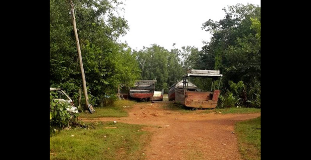 Boats moored at the end of Independence Road, where the roadway meets the Aruka River