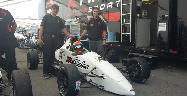 Calvin Ming sits in the Team K-Hill Motor sports F1600 car. He is flanked by his technicians