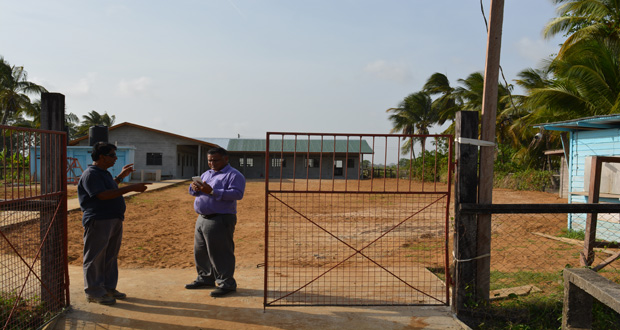 Government Councillor on the island of Leguan, Dr Kamal Roy Narine and advisor to the Prime Minister Harry Narine Deokinanan in discussion in front of the new Endeavour (East Leguan) Primary School.