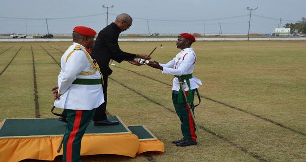 Commander-in-Chief of the Armed Forces, David Granger hands over the award of the sword of honour to Best Graduating student Cleveroy Patrick during the parade
