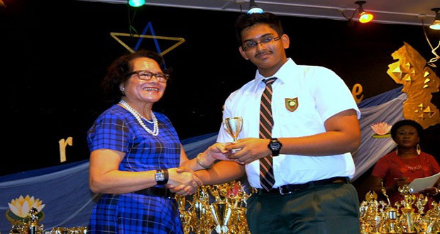 First Lady Mrs Sandra Granger presents a trophy to Form Two student Krishan Singh (Ministry of the Presidency photo)