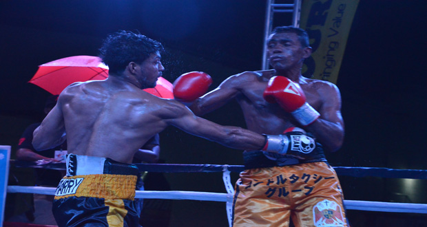 Elton `The Bully’ Dharry (left) connects with a right dig to the body of Felif Machado during their 10-round bantamweight fight at the Giftland Mall on Saturday night.
