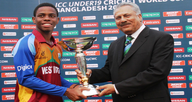 A smiling  West Indies captain Shimron Hetmyer receives the Under-19 trophy from ICC president Zaheer Abbas.