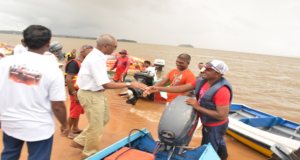 President David Granger greeting at the Golden Beach some of the racers who participated in the Bartica Regatta 
(Sandra Prince/Ministry of the Presidency photo)
