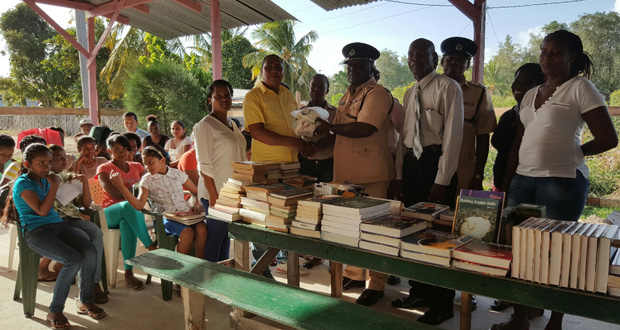 Commander Mansell of the Police ‘D’ Division handing over the books and sports gear to Director of the Best United Community Group, Antonio Paul