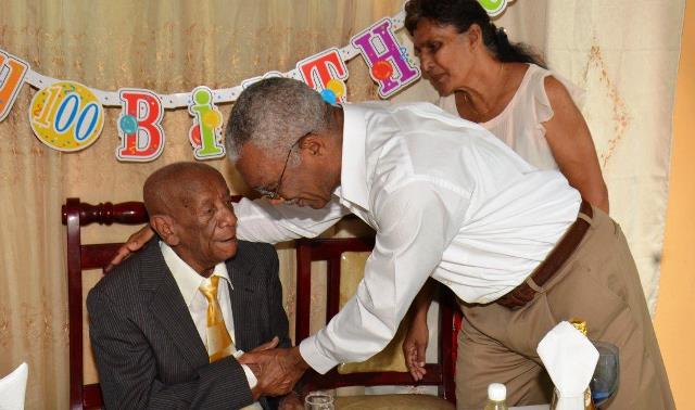 President Granger congratulates Mr Charles Allicock on his 100th birthday. Also in photo is Mr Allicock’s caretaker, Bibi Fagu (Sandra Prince/Ministry of the Presidency photo)