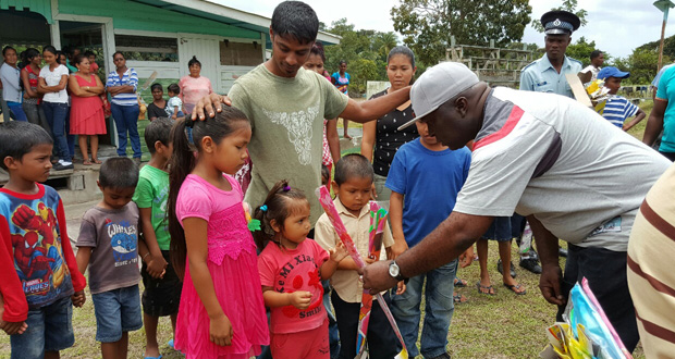 Commander Mansell presenting kites to children of Bonasika Creek