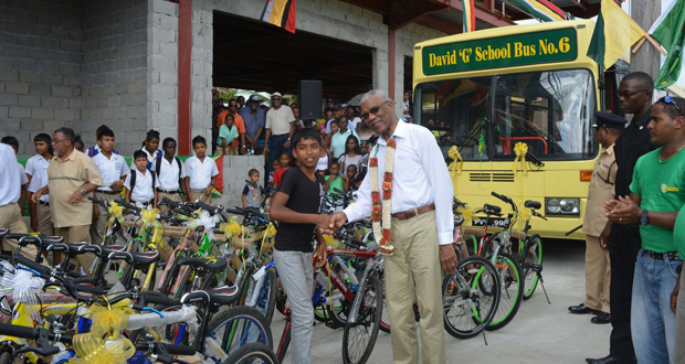 A Bartica lad shakes hands with President David Granger at the ceremony to hand over a 50-seater bus and bicycles for use by children of Bartica and surrounding communities.