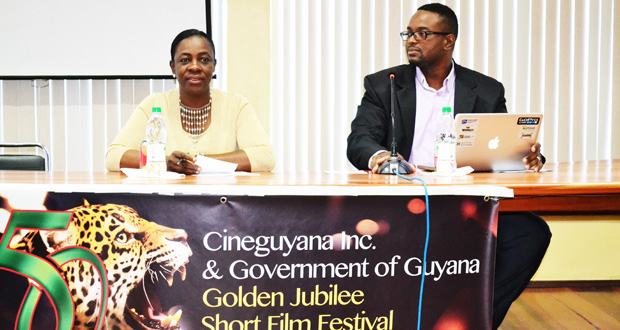 Minister within the Ministry of Education, with responsibility for Youth, Sport and Culture, Nicolette Henry, making a point while CeneGuyana President Phillip Williams looks on at the launch of the Golden Jubilee Film Festival on Friday (Photo compliments of the Ministry of Education)