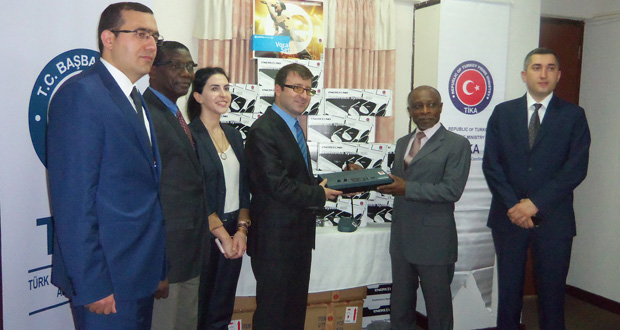 Foreign Affairs Minister Carl Greenidge receives one of the many conference systems from TIKA Coordinator Mehmet Ozkan in the presence of other officials.