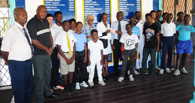 CEO of Global Seafood Distributor Allison Butters-Grant (left) presents the cheque to MSC secretary Adrian Smith in the presence of young cricketers and officials of the club and sponsors
