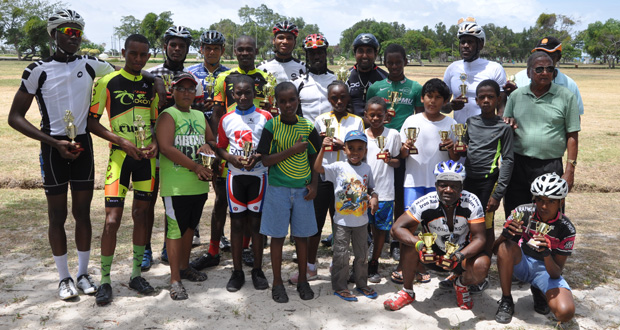 Winner of yesterday’s Star Party Rentals feature 35-lap cycle race, Team Evolution’s Orville Hinds (center with trophy) and other prize winners of the various categories strike a pose with race organiser Hassan Mohamed (extreme right).