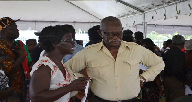 Minister of Citizenship, Winston Felix, listens keenly as a citizen airs her complaints at the outreach at New Amsterdam