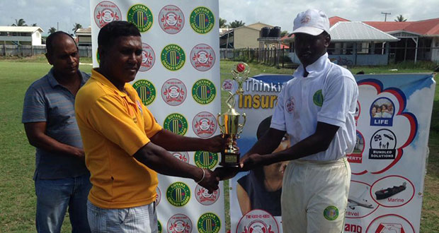 Kevin Sinclair collects the man-of-the-match trophy from president of the Enterprise Busta Sports Club, Seemangal Yadram.