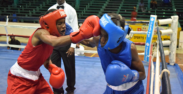 Delroy Elcock (left) and Joel Allicock exchange punches during their junior flyweight contest at the Cliff Anderson Sports Hall on Friday evening (Cullen Bess-Nelson photo).