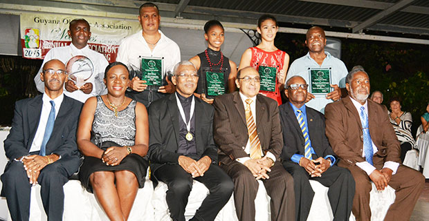 (Standing) L-R Award winners, representative of Buxton Youth Development Organisation, Sean Devers, Larissa Wiltshire, Taylor Fernandes and  Carl Ince. 
 (Sitting): President David Granger third from left is   flanked  by Garfield Wiltshire, Minister Nicolette Henry, GOA President K. Juman  Yassin, Ivor O’Brien and Hector Edwards