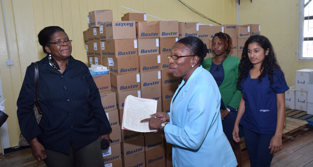 Administrative Manager Yvonne Bullen shows reporters a list of medications currently in stock at the Georgetown Public Hospital. At left is GPHC Pharmaceutical Department Manager June Barry. Others in photo are Pharmacists Merecia Blenman and Mellisa Ramnarine (Cullen Bess-Nelson)