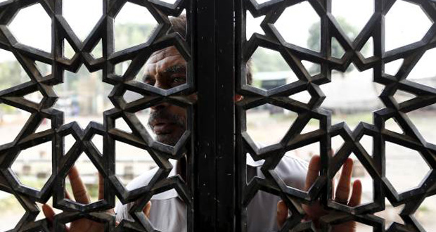 A man says a prayer from outside the window of the shrine of Bari Imam on the outskirts of Islamabad, Pakistan, April 27, 2015. REUTERS/Caren Firouz)