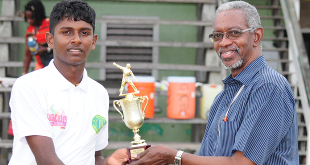 Off-spinner Sagar Hatheramani collects the man-of-the-match trophy from match referee Grantley Culbard.