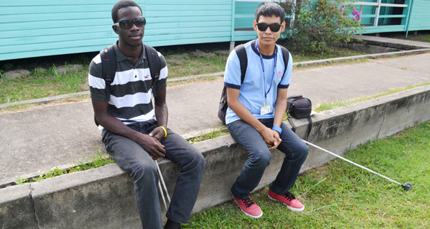 Ceion and his friend Asif Khan sit outside the Centre for Communication Studies at the Turkeyen Campus recently. Khan is also pursuing studies in the social sciences field at UG.