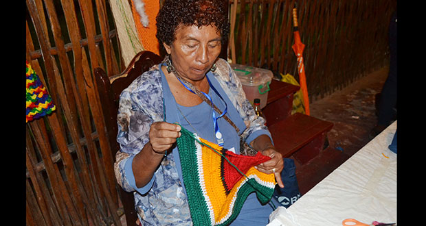 Bridget Alleyne knits an item which is made in the colours of the Golden Arrowhead