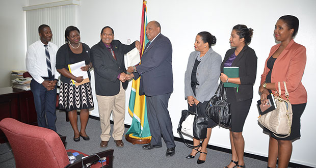 Prime Minister Moses Nagamootoo receiving the report from Code of Conduct Sub-Committee Chair, Minister Raphael Trotman. He is flanked by OPM staff at left, and sub-committee members at right