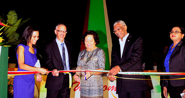 First Lady Sandra Granger is assisted by President David Granger and Minister of Business, Dominic Gaskin, in cutting the ribbon to officially declare GuyExpo 2016 open.