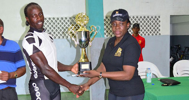 : Overall winner and successful defending champion of the Annual Independence Three-Stage Cycle Road Race, Orville Hinds (left), accepts his  trophy from Minister of Sport Nicolette Henry yesterday at the Cliff Anderson Sports Hall.