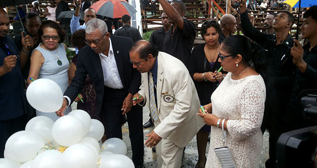 President David Granger and Prime Minister Moses Nagamootoo along with their spouses writing their personal commitments to the promotion of social cohesion on white helium filled balloons, which were later released up into the sky. (Office of the Prime Minister photo)