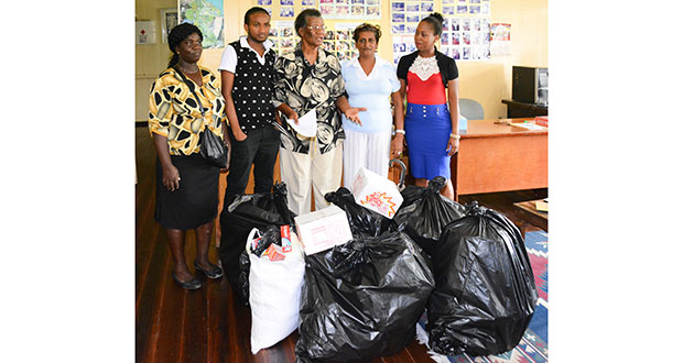 Fire victims Nicola Junor, Sadam John, Sandra John and Yonika Munroe received donations from Administrative Officer of the Guyana Relief Council, Ms. Lynette Cater, (centre)