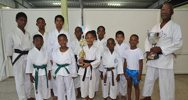 Sensei Winston Dunbar and Sadella Britton hold trophies with the other participants.