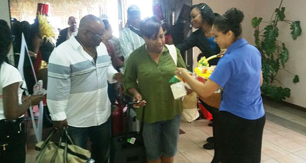 Staff distributing samples to arriving visitors at CJIA