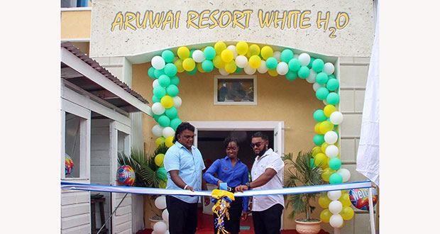 Chunilall Baboolall, left, joins in cutting the ribbon to mark the opening the Aruwai Resort’s Georgetown Office