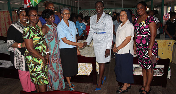 Minister within the Ministry of Education, Nicolette Henry, shakes hands with representatives of the Canada- based ‘GT 50 Group’ during its presentation of beds to the St. Ann’s Orphanage