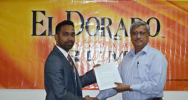 Trevor Bassoo, Guyana Amazon Warriors Marketing and Sponsorship Manager (left) holds the signed contract with Komal Samaroo, Demerara Distillers Limited Executive Chairman.
