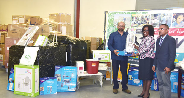 Dr Bari (extreme left) hands over equipment to Dr Karen Cummings in the presence of the foundation’s secretary, Otillo Pereira.