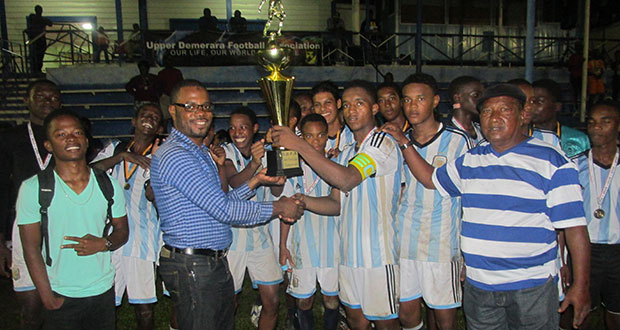 Eagles captain Javair Smith is presented with the winners’ trophy by Sharma Solomon, president UDFA.