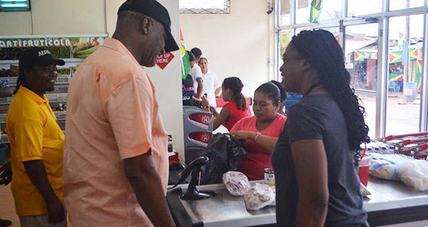 Minister Harmon is interacting with a resident of Mahdia at a supermarket in the area. At left is prominent Mahdia businessman Roger Hinds