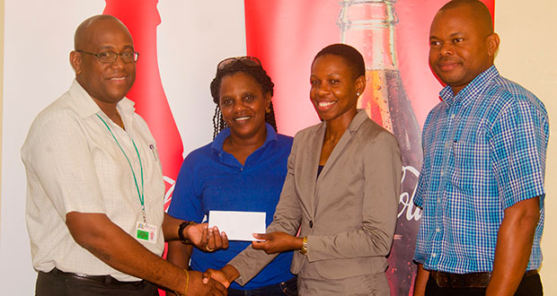Athletic star Aliann Pompey receives the sponsorship cheque from Brand Manager Clive Pellew while Meet official Mayfield Taylor-Trim and Banks DIH’s Kester Van-Nooten look on.