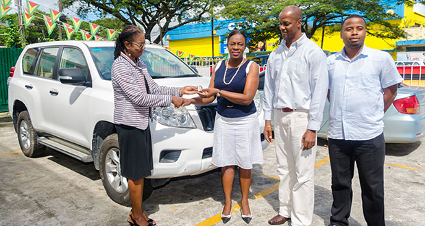UNFPA Resident Representative Patrice La Fleur (left) handing over the keys to the Prado to Minister within the Education Ministry, Nicolette Henry, in the presence of Alfred King, Permanent Secretary in the Ministry of Education’s Department of Culture, Youth and Sport, and Trevor Williams, also from the Department of Culture, Youth and Sport (Delano Williams photo)