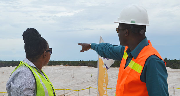 Minister Patterson points in the direction of extension works being undertaken at the south-western end of the main runway at the CJIA, as minister within the Ministry of Public Infrastructure Annette Ferguson looks on